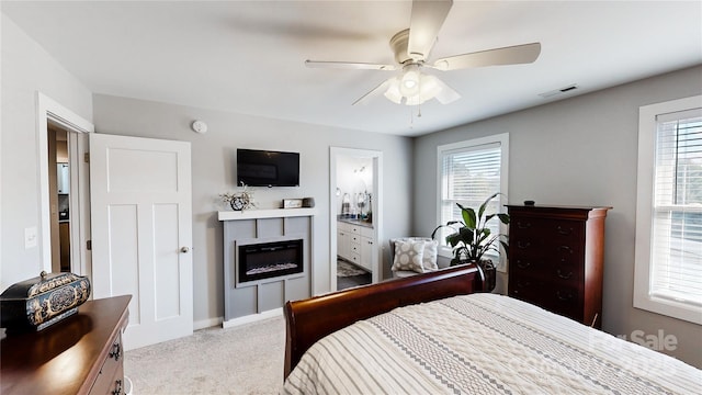 bedroom with visible vents, baseboards, ceiling fan, carpet floors, and a glass covered fireplace