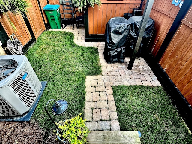 view of yard featuring central AC unit and fence
