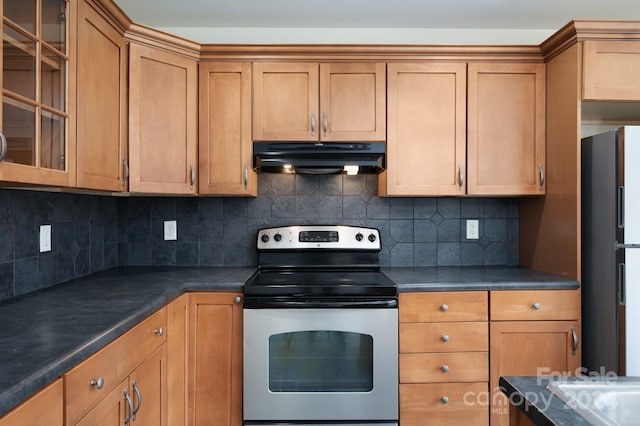 kitchen featuring fridge, stainless steel range with electric cooktop, and backsplash