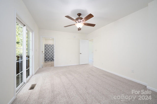 carpeted spare room featuring ceiling fan