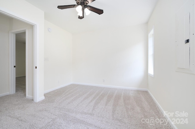 carpeted spare room featuring electric panel and ceiling fan