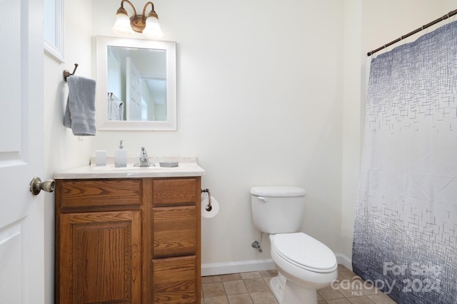 bathroom featuring toilet, walk in shower, vanity, and tile patterned floors