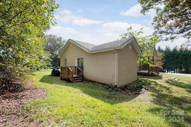 view of side of property featuring a deck and a lawn