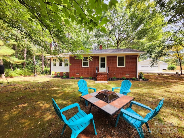 rear view of property with a lawn and a fire pit