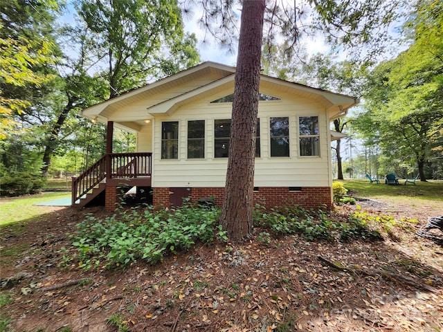 view of property exterior with crawl space and stairway