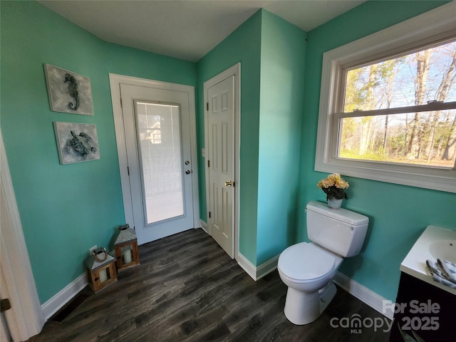 bathroom with toilet, baseboards, wood finished floors, and vanity