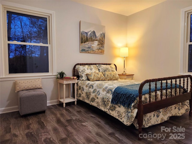 bedroom with dark wood-style floors and baseboards