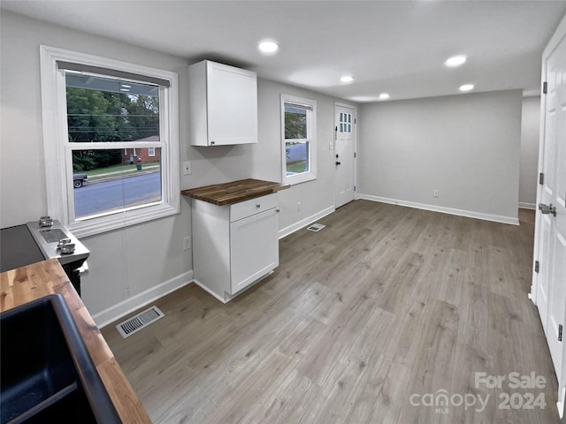 kitchen featuring light wood-type flooring, white cabinetry, and wood counters