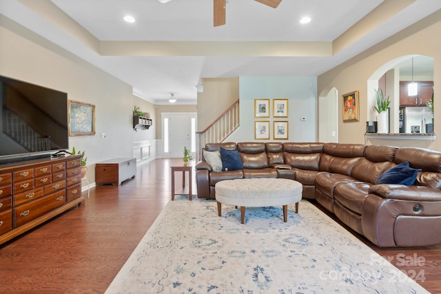 living room with ceiling fan and dark hardwood / wood-style flooring