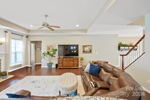 living room featuring dark wood-type flooring and ceiling fan