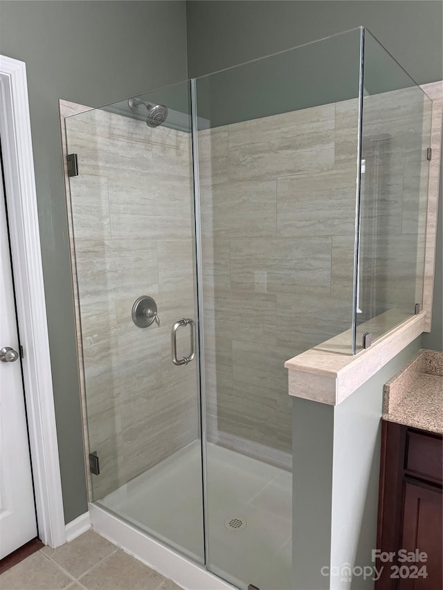 bathroom with walk in shower and tile patterned floors