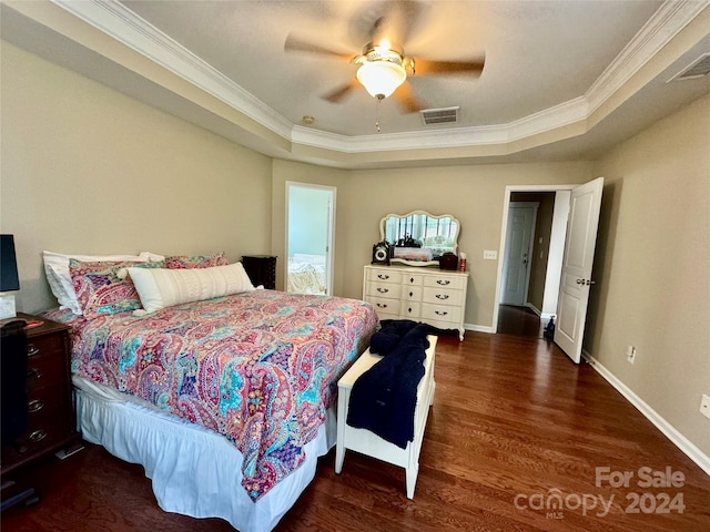 bedroom with ornamental molding, dark wood-type flooring, ceiling fan, and a tray ceiling