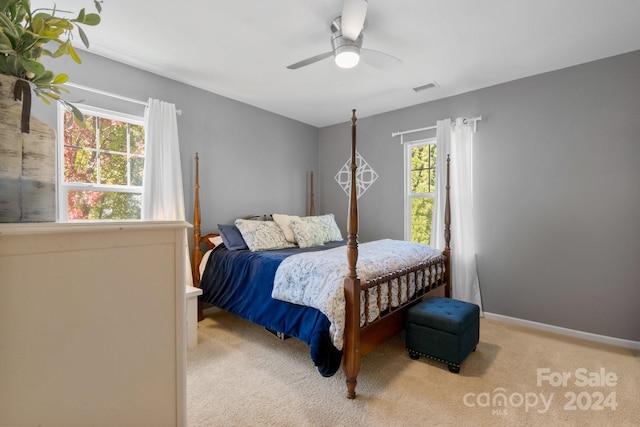 carpeted bedroom with multiple windows and ceiling fan