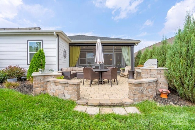 view of patio / terrace with a sunroom and exterior kitchen