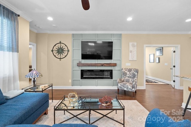 living room with a fireplace, hardwood / wood-style flooring, ceiling fan, and crown molding