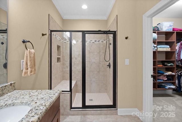 bathroom with vanity, a shower with shower door, and crown molding