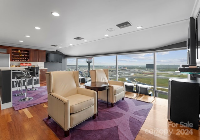 living room with hardwood / wood-style flooring, vaulted ceiling, and a wealth of natural light