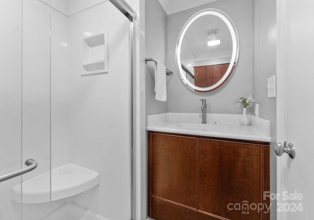 bathroom featuring ornamental molding, a shower with door, and vanity