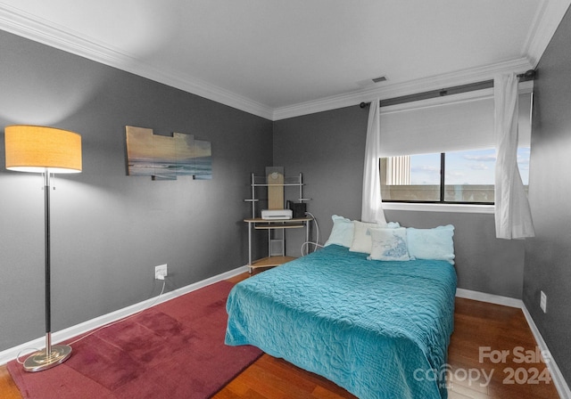 bedroom with crown molding and hardwood / wood-style floors