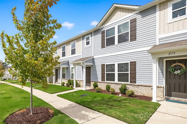 townhome / multi-family property featuring a front lawn