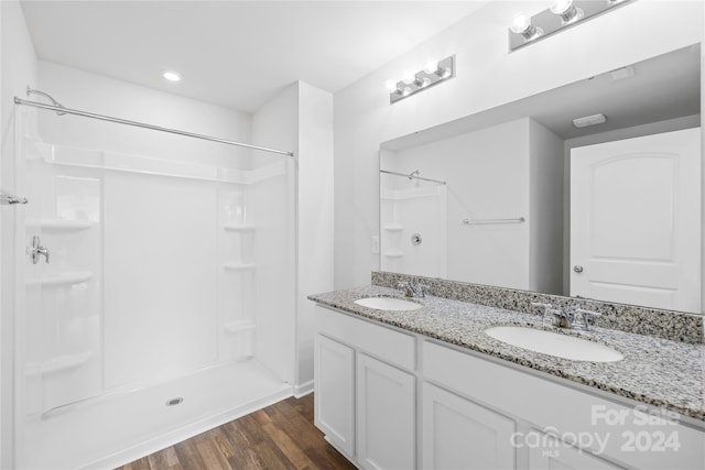 bathroom featuring a shower, vanity, and hardwood / wood-style floors