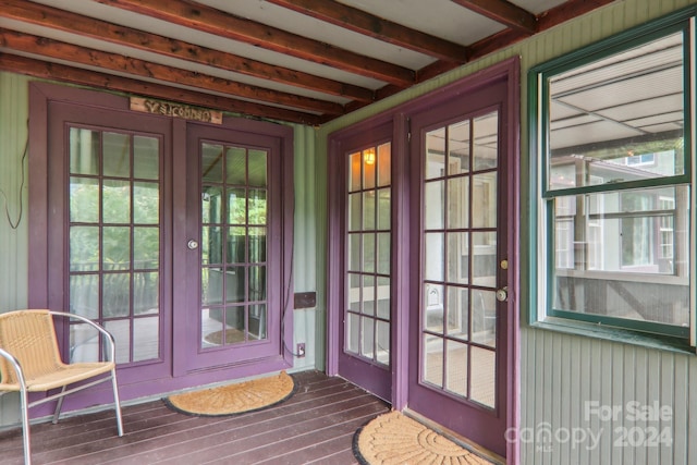 doorway with wood-type flooring and beam ceiling