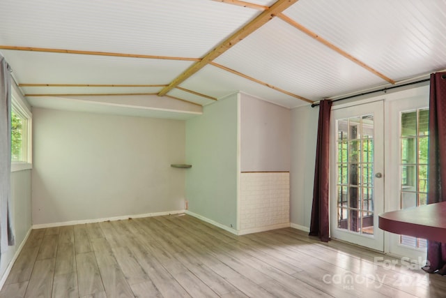 unfurnished room featuring lofted ceiling, french doors, and light wood-type flooring