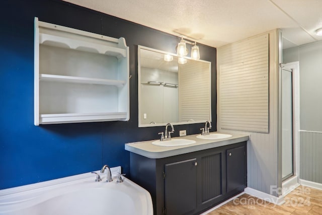 bathroom with independent shower and bath, a textured ceiling, vanity, and hardwood / wood-style floors