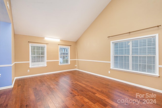 empty room featuring high vaulted ceiling and hardwood / wood-style flooring