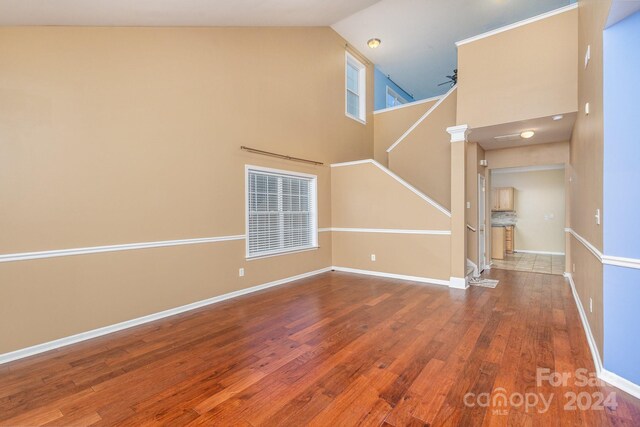 unfurnished living room with ceiling fan, high vaulted ceiling, and hardwood / wood-style flooring