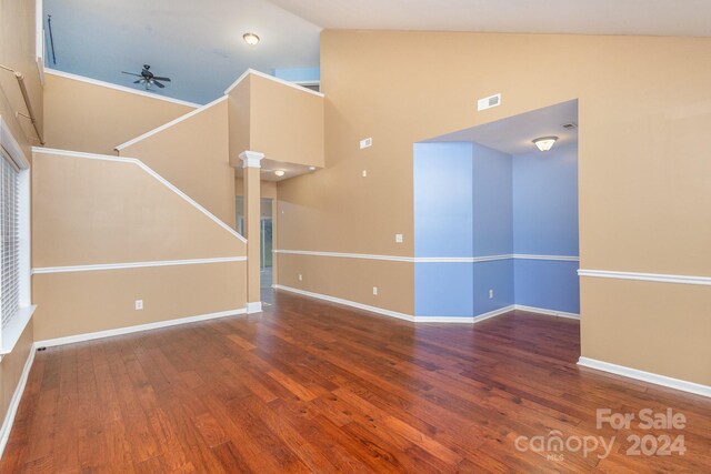 unfurnished living room with ornate columns, wood-type flooring, ceiling fan, and high vaulted ceiling