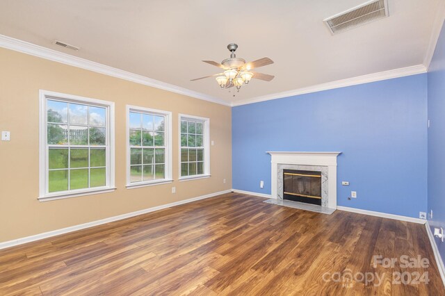 unfurnished living room featuring crown molding, dark hardwood / wood-style floors, a high end fireplace, and ceiling fan