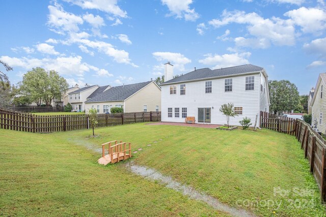 rear view of house with a lawn and a patio area