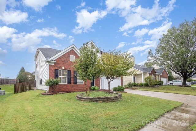 view of front of property with a front yard and central AC unit