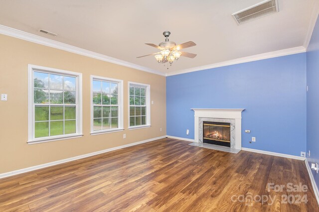 unfurnished living room with ornamental molding, ceiling fan, a fireplace, and dark wood-type flooring