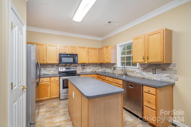 kitchen with ornamental molding, sink, tasteful backsplash, appliances with stainless steel finishes, and a center island