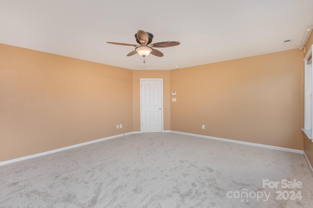 carpeted spare room with ceiling fan