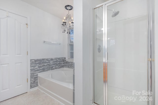 bathroom with plus walk in shower, tile walls, tile patterned flooring, and an inviting chandelier