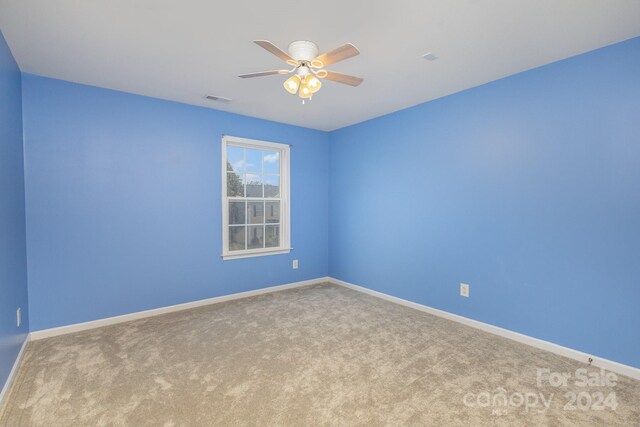 carpeted empty room featuring ceiling fan