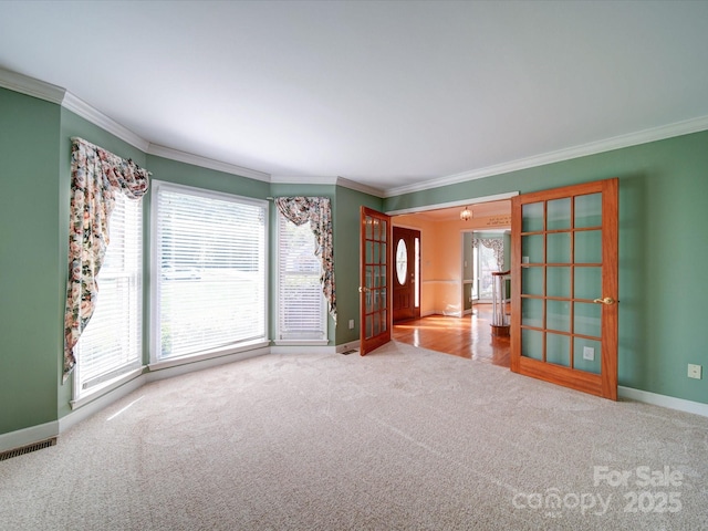 spare room with ornamental molding and carpet