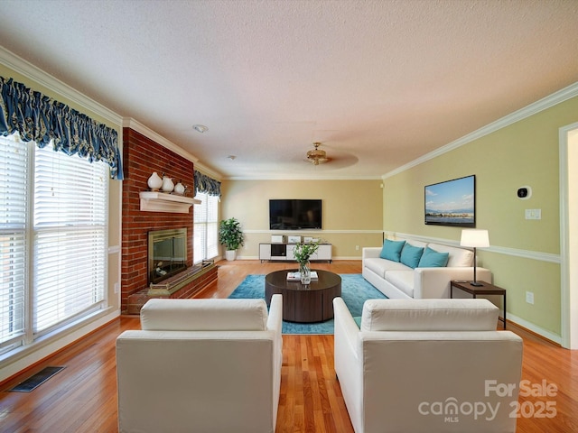 living room with a wealth of natural light, a fireplace, and light hardwood / wood-style floors