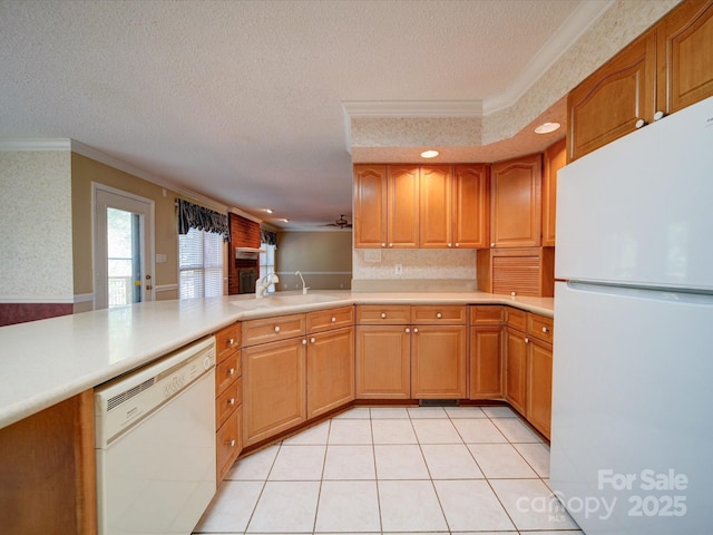 kitchen featuring sink, a textured ceiling, ornamental molding, kitchen peninsula, and white appliances