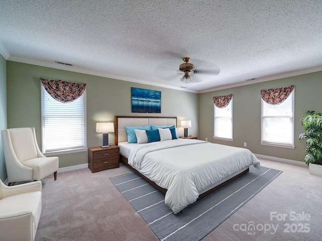 carpeted bedroom with ceiling fan, ornamental molding, and a textured ceiling