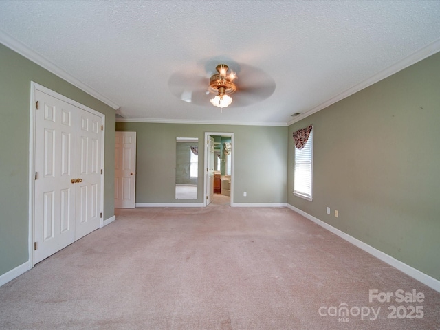 spare room featuring ornamental molding, light carpet, and a textured ceiling