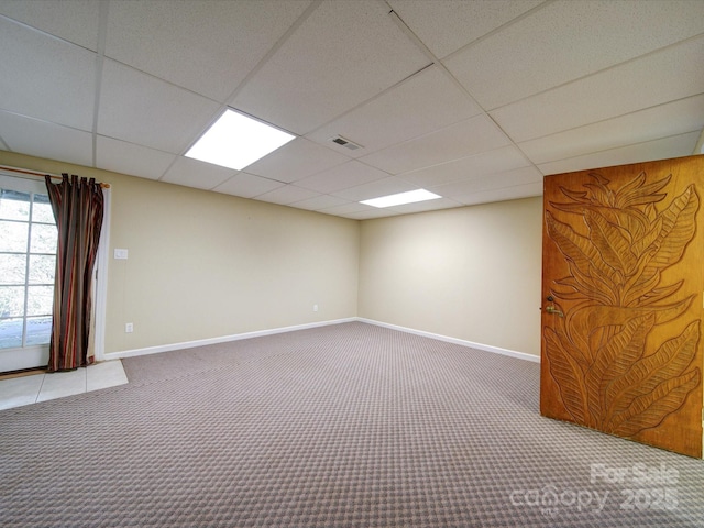 basement with carpet floors and a paneled ceiling