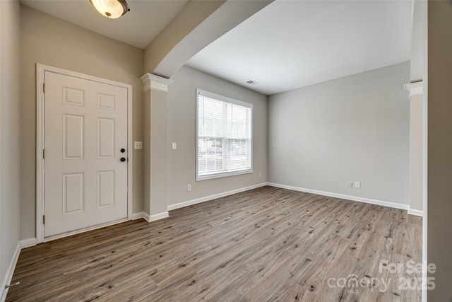 entrance foyer with decorative columns and light wood-type flooring