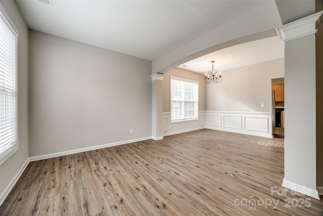 unfurnished room with light hardwood / wood-style floors and a notable chandelier