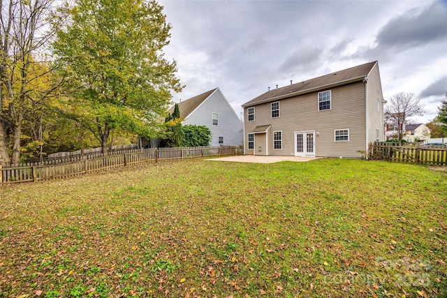 rear view of property featuring a yard, a patio area, and french doors