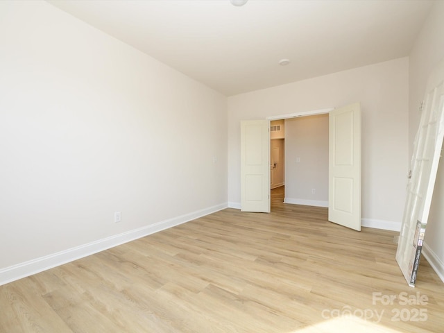 unfurnished bedroom with light wood-type flooring and baseboards