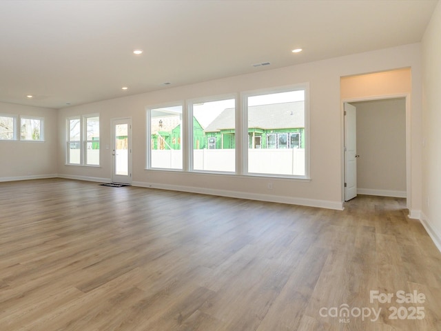 unfurnished living room with recessed lighting, visible vents, baseboards, and light wood-style floors